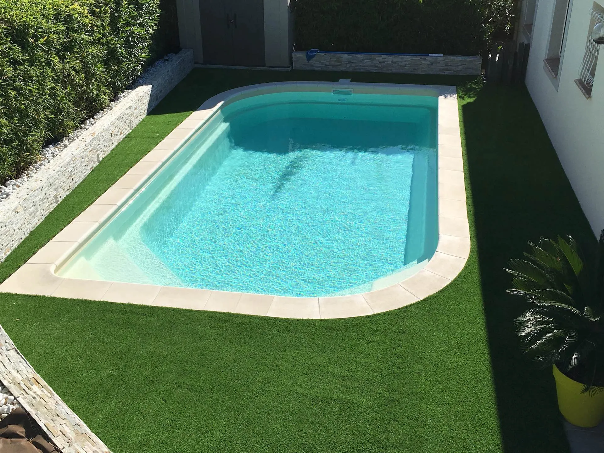 Finitions de gazon synthétique le long d'un muret près de Montpellier